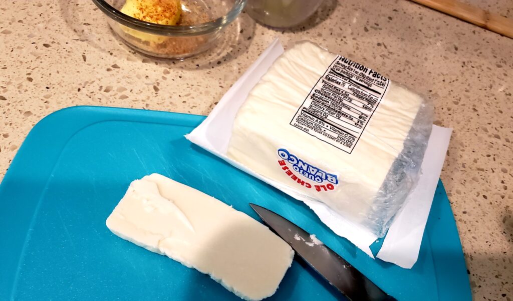 blue cutting board with sliced queso blanco