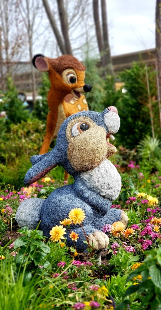 topiaries thumper and bambi on top of small green and colorful flowers