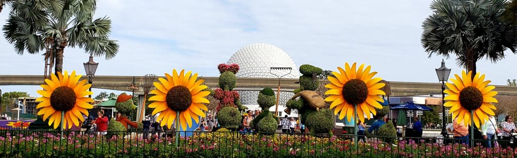 epcot ball with giant sunflowers and topiaries