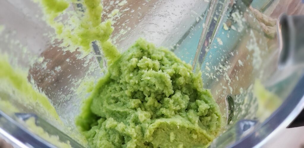 looking down into a blender with celery paste in it