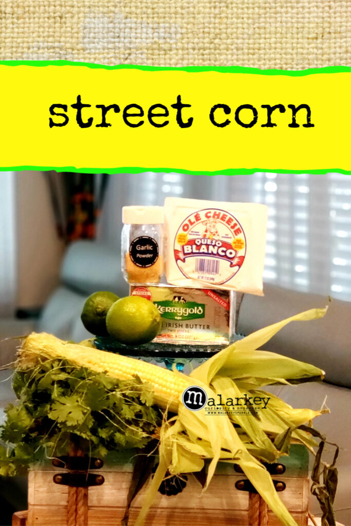 street corn ingredients stacked up on chest - corn cilantro garlic butter and queso blanco