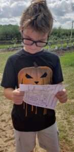 boy with pumpkin shirt reading a map