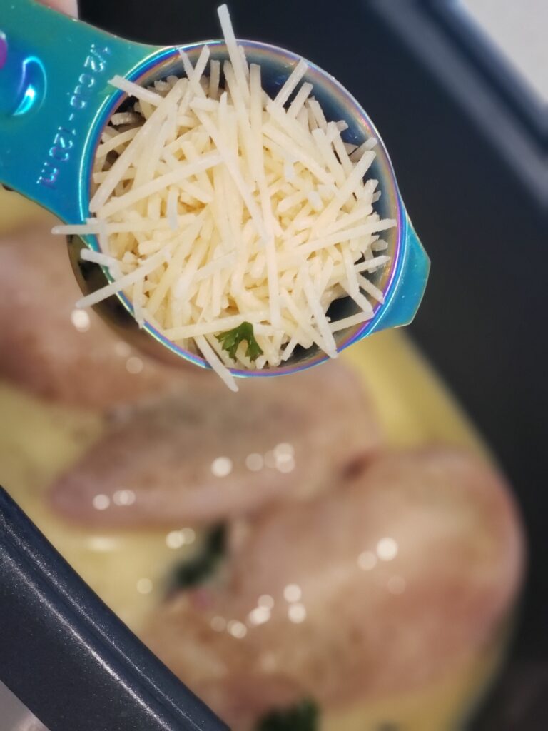 parmesan cheese in a cup over crockpot of chicken
