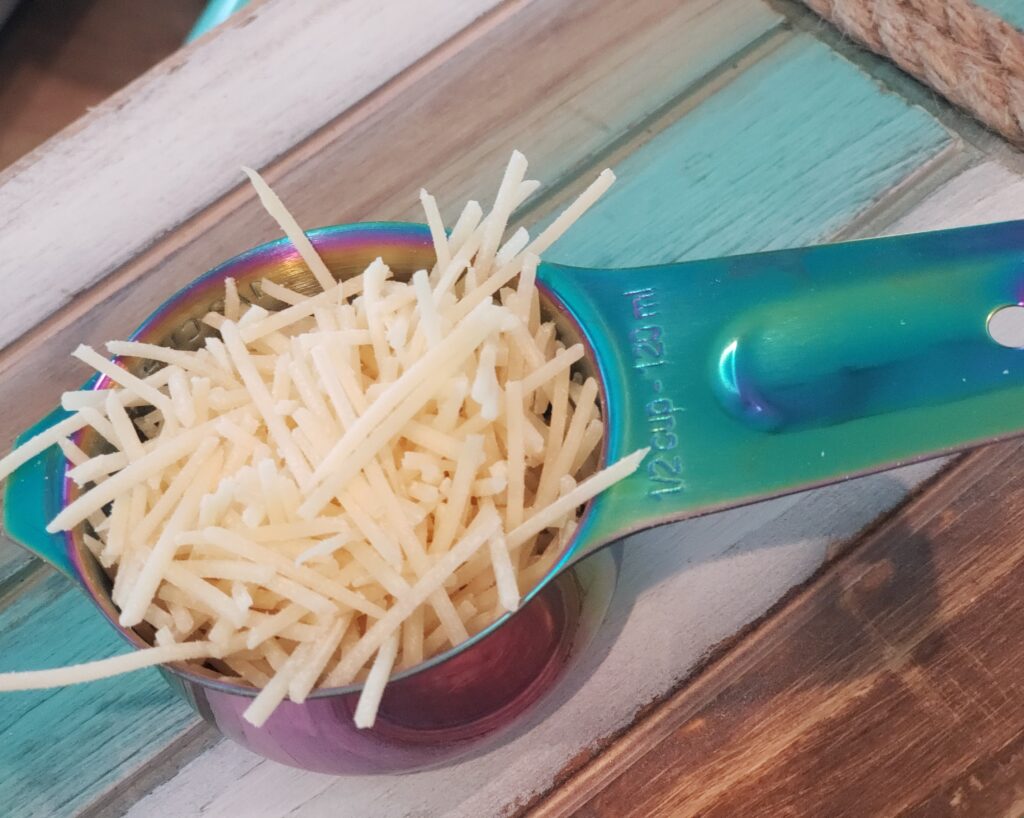 a measuring cup with cheese in it