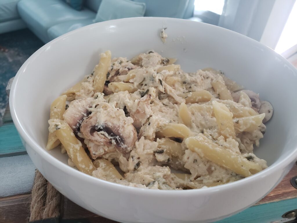 white bowl with penne pasta and creamy chicken with mushrooms