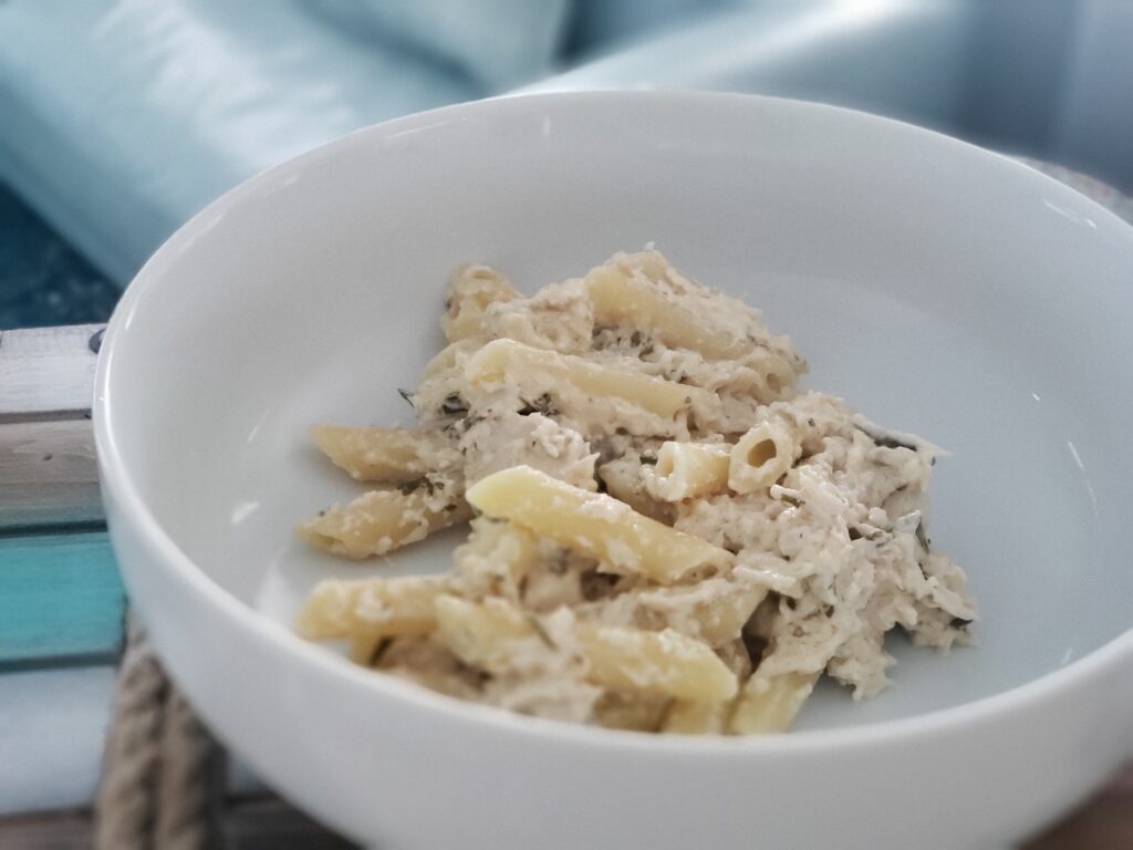 white bowl with penne pasta and creamy chicken