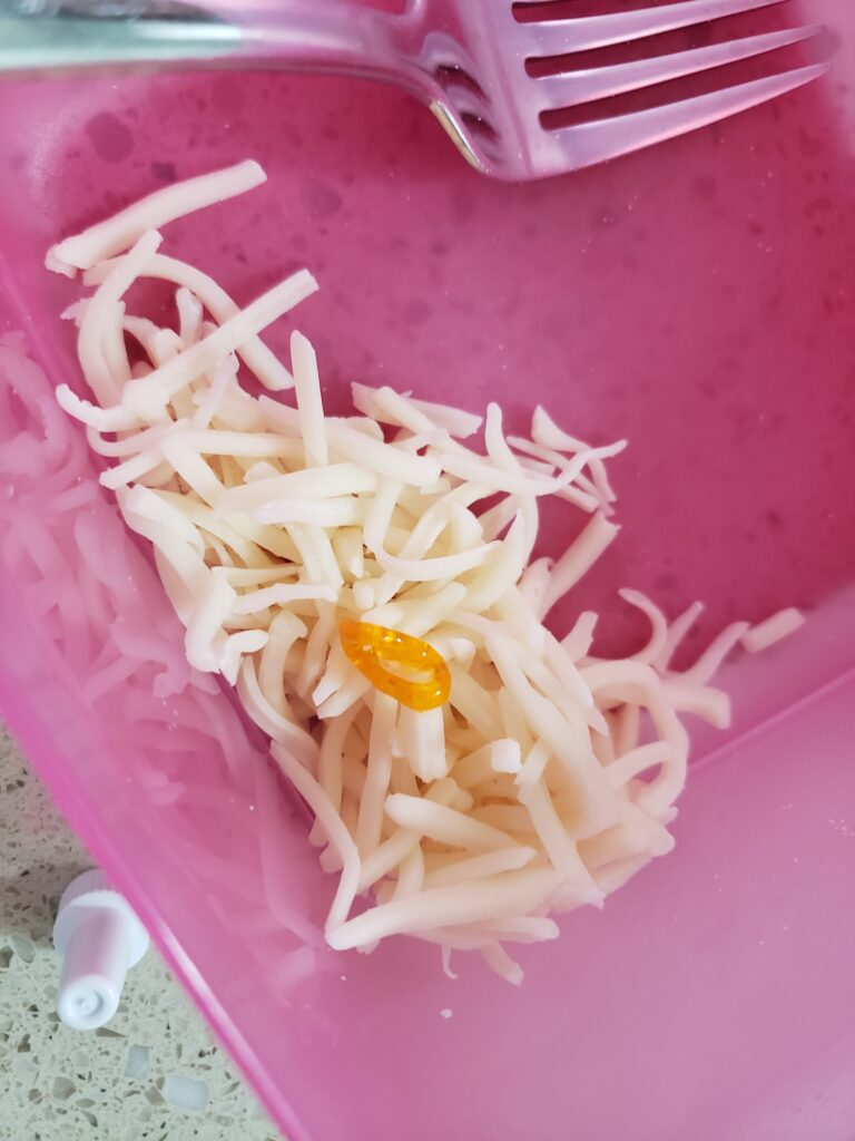 mozzarella cheese with yellow food coloring in a pink bowl