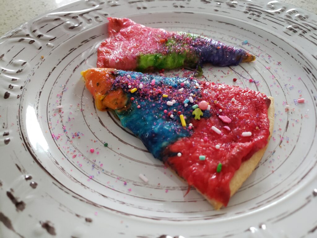 rainbow pizza - sliced on a plate with sprinkles
