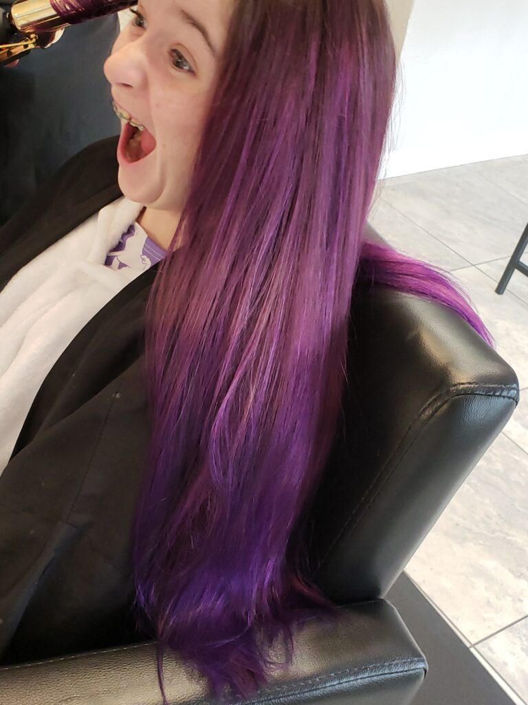 a girl with purple hair with her mouth open excied