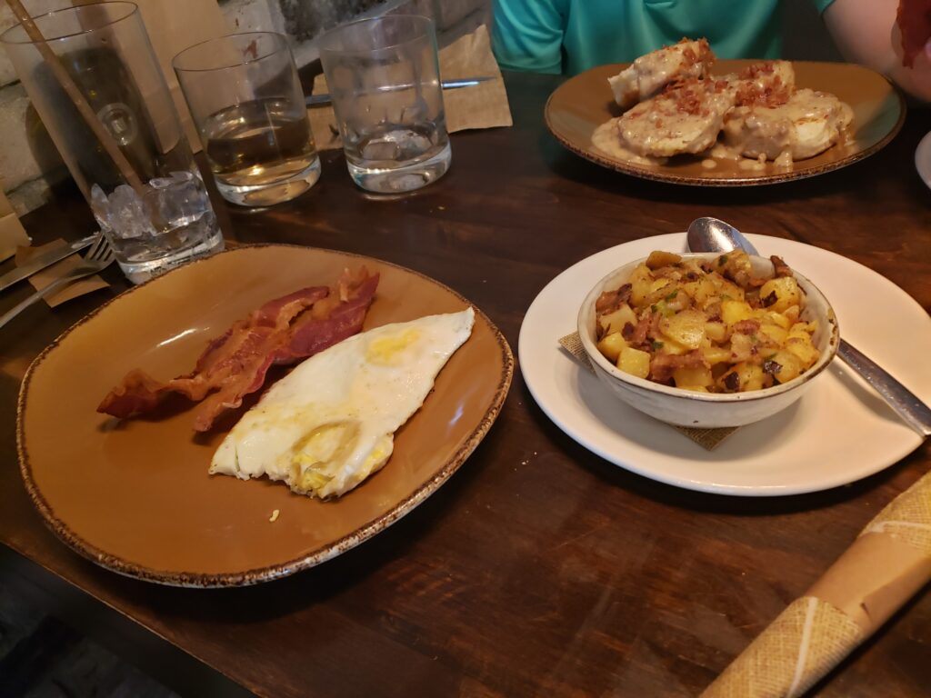 wine bar george eggs, bacon, potatos and biscuits on table
