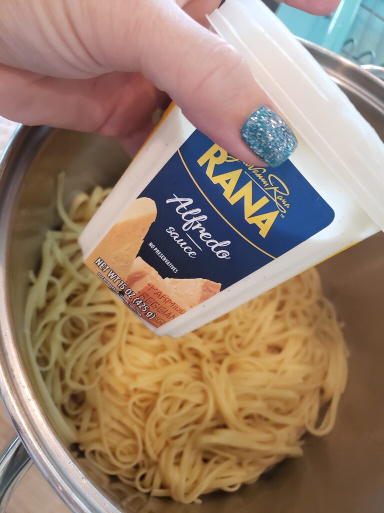 linguine in a pot with rana sauce over it