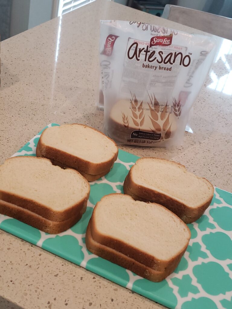 artesano bread package in front of a cutting board with 8 slices of bread