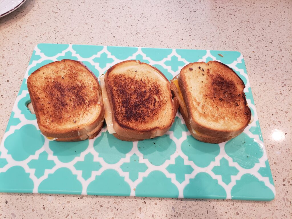 grilled cheese on a cutting board side by side 3 of them