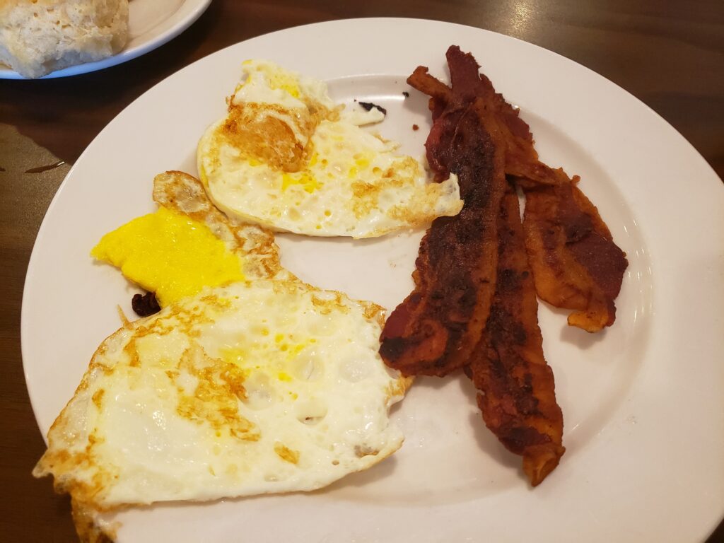 2 eggs and bacon on a white plate