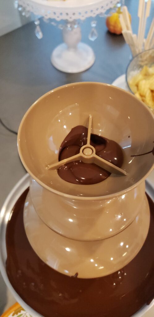 The Epic Chocolate Fountain on a table with chocolate starting to come out of the top