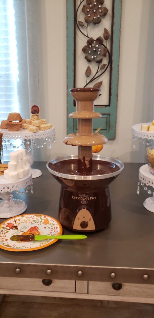 The Epic Chocolate Fountain on a table with chocolate dripping from it
