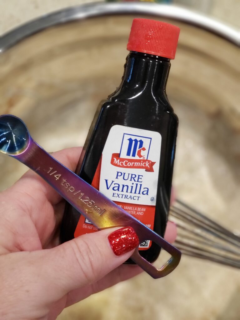 vanilla and a 1/4 teaspoon in a womans hand