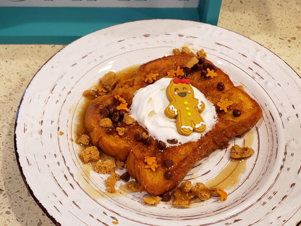 french toast on a plate with whip cream and a little cookie