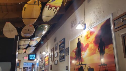 inside a restaurant with surf boards on the roof