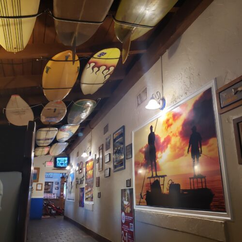 inside a restaurant with surf boards on the roof