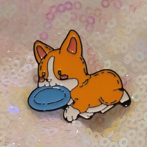 corgi with a frisbee pin